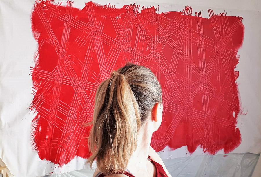 Artist Paraskevi in front of a red artwork