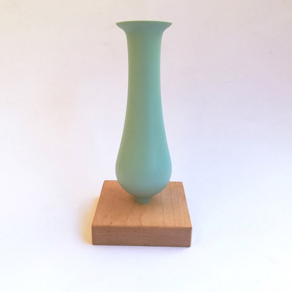 Blue dip moulded plastic vase with wooden base.