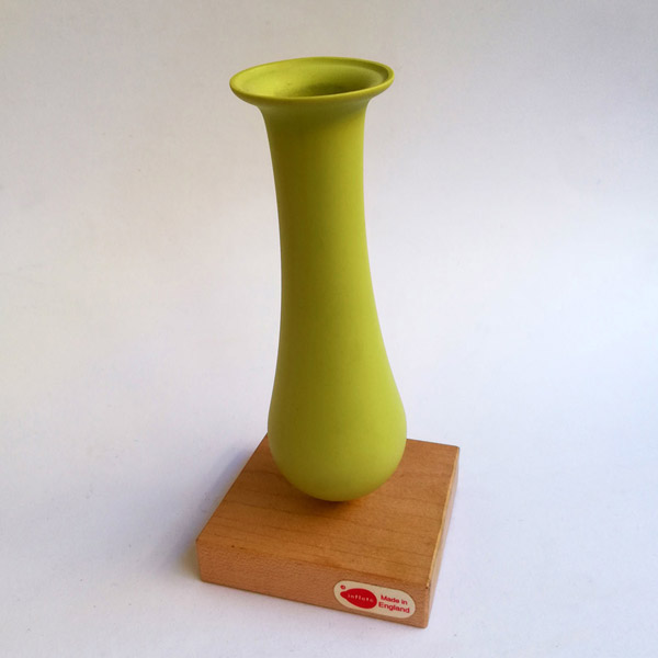Lime dip moulded plastic vase with wooden base.