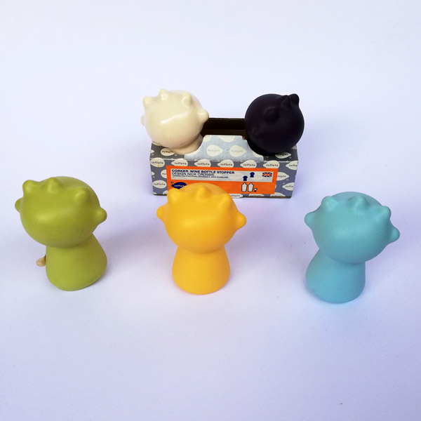 Five dip moulded plastic bottle tops in various colours.