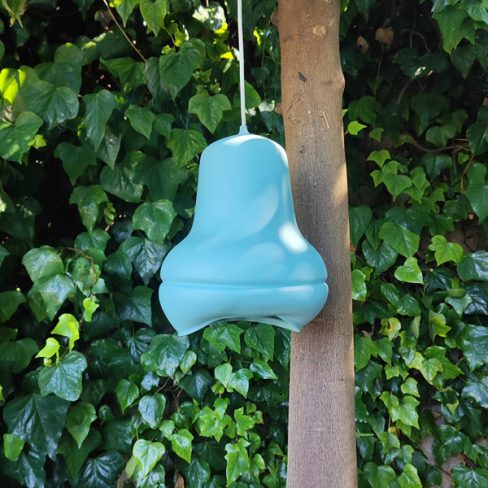 Blue dip moulded plastic pendant light hanging from a tree.