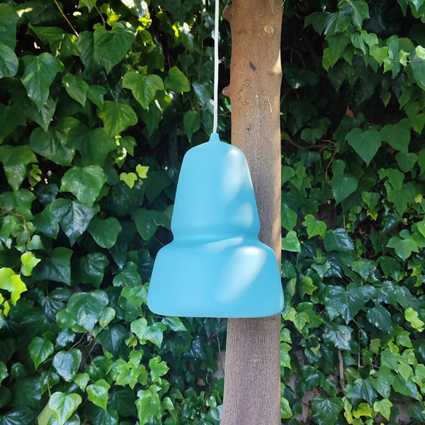 Blue dip moulded plastic pendant light hanging from a tree.