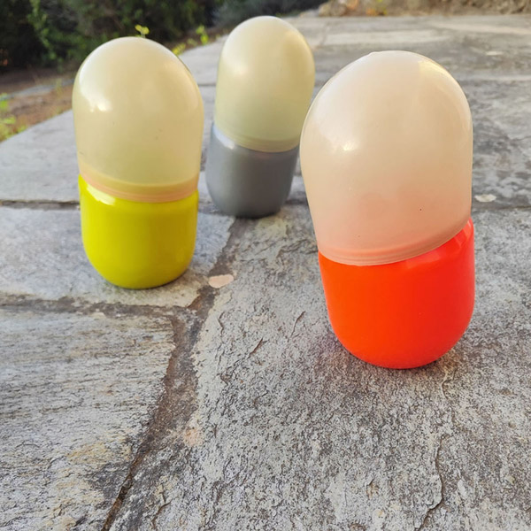 Three dip moulded plastic pill-shaped boxes.