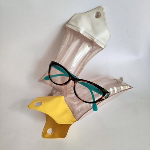 A white and a yellow inflatable sunglass case and a pair of reading glasses.